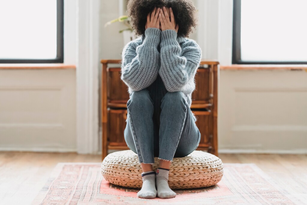 Woman sitting with face in hands