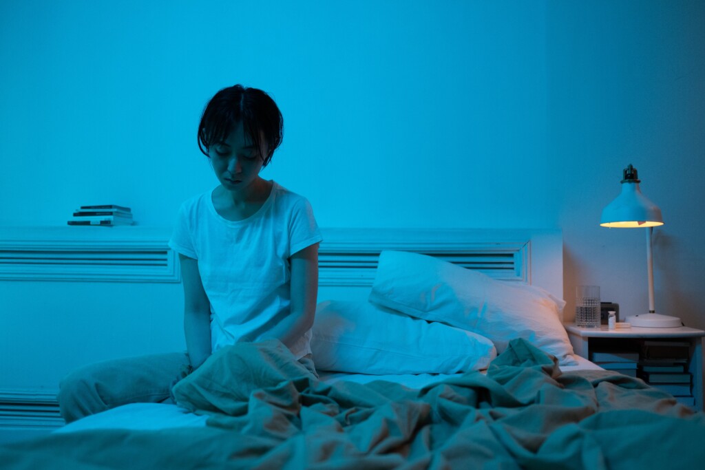 Person sitting on bed alone