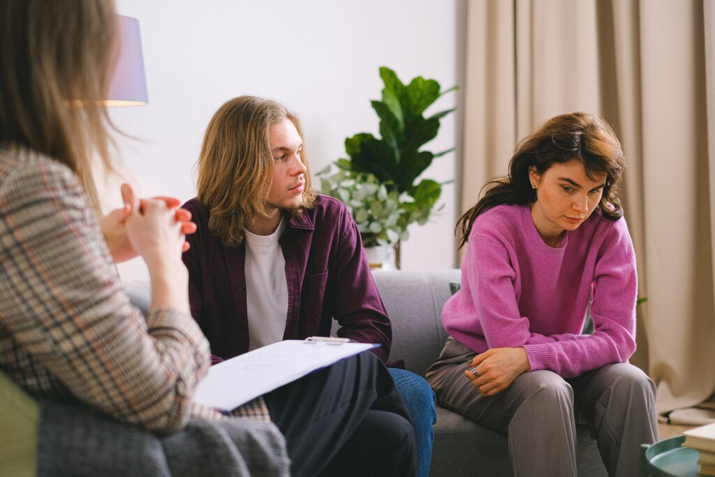 Couple sitting on couch talking in therapy