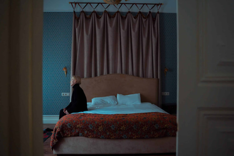 Person sitting alone on a bed
