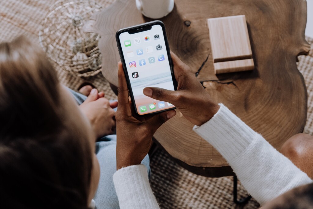 Person holding phone with social media applications showing