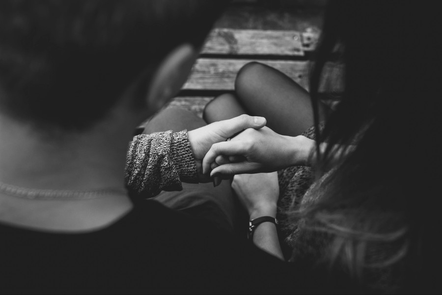 Black and White photo of couple holding hands.