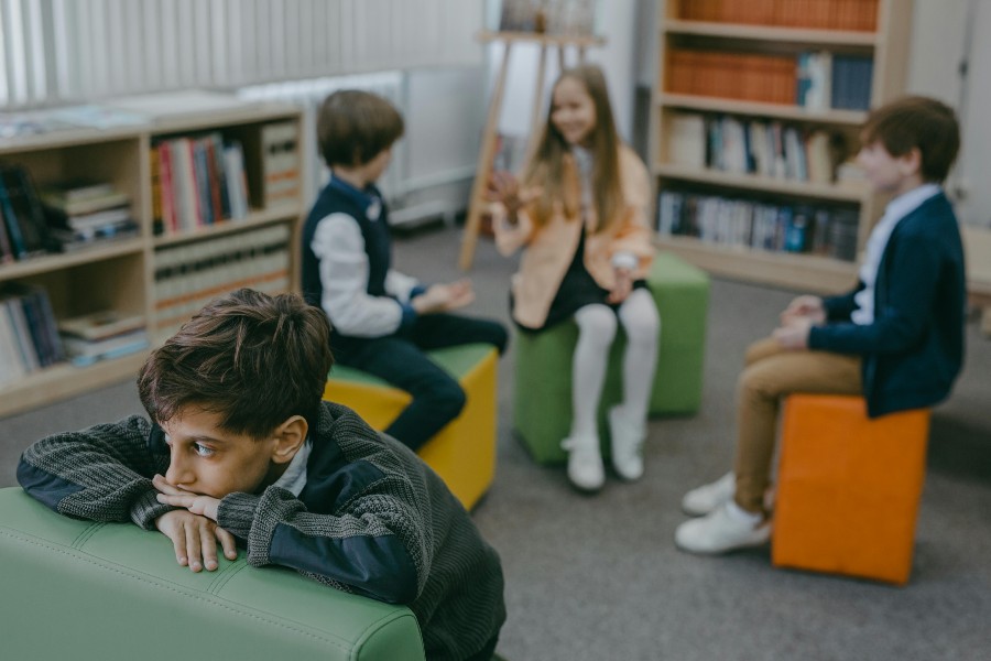 child sitting away from other children in room